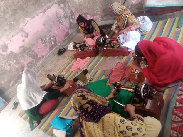 A group of women sewing on a rug

Description automatically generated