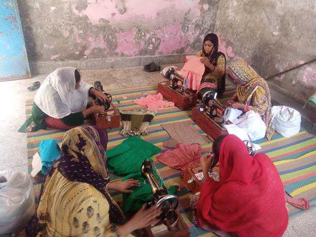 A group of women sewing on a rug

Description automatically generated