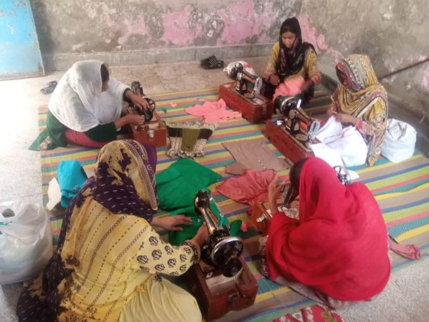 Women sitting on the floor sewing

Description automatically generated